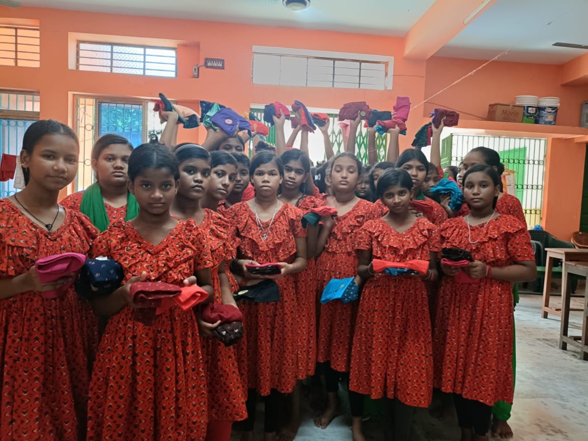 Girls holding puja clothes at Pranab Kanya Ashram